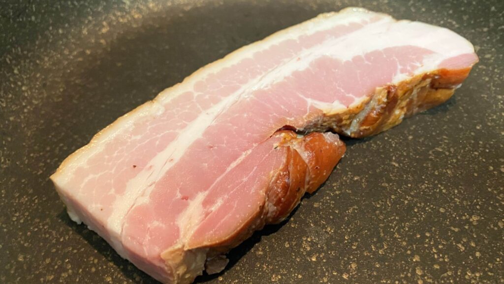 冷たい状態のフライパンにベーコンを並べる